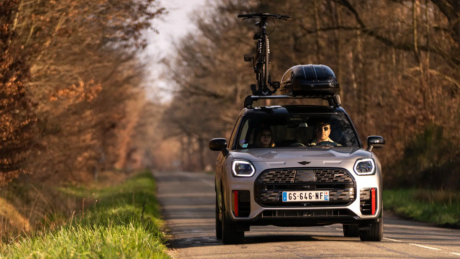 MINI Countryman with roof box on the road.